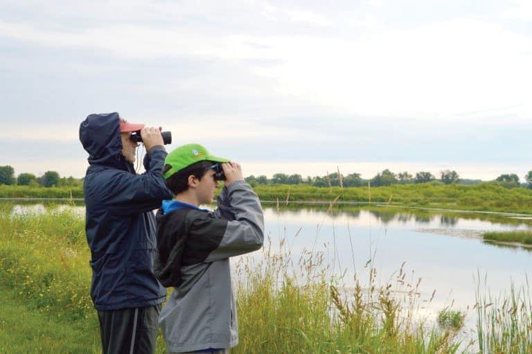 MetroParks to offer walks, hikes, nature explorations. This picture depicts two people observing wildlife at the Mill Creek Wildlife Sanctuary in Canfield. Mill Creek Metroparks will host Birding the Sanctuary on July 19 and Aug. 16 at the Mill Creek Wildlife Sanctuary, 2650 W. Calla Road, Canfield 44406. Call 330-702-3000 for more information or visit millcreekmetroparks.org. Image courtesy of Mill Creek MetroParks