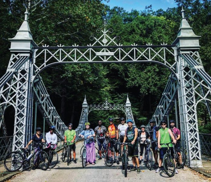 Youngstown Events | June 24-30, 2025 | Metro Monthly | Our guide covers the Youngstown-Warren area, Columbiana County and western Pennsylvania. The CycWard Bike Club hosts bike rides throughout summer. Participation is open to the community. Visit the group’s Facebook page for information. Image depicts cyclists at the silver suspension bridge at Mill Creek MetroParks. Image courtesy of CycWard Bike Club and Joe Parent. Photo by Kim Ruble.
