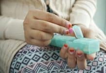 This image depicts a woman picking up a pill from a pill carrier. Penn State to offer webinars on substance-use education.